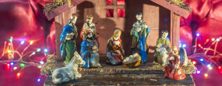 Wooden nativity creche or stable with colorful porcelin religious figurines celebrating The Ephiphany - The Spiritual Way to arrive at your destination.