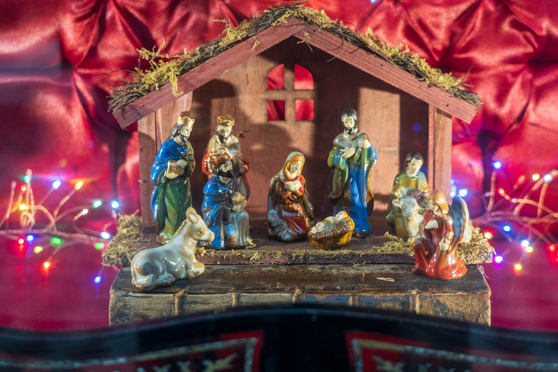 Wooden nativity creche or stable with colorful porcelin religious figurines celebrating The Ephiphany - The Spiritual Way to arrive at your destination.